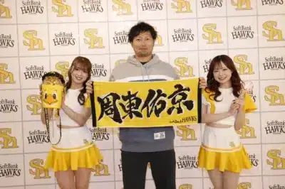 福岡ソフトバンクホークスのロゴを背景に、周東佑京選手とチアガール