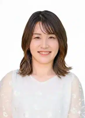 白い背景の前で笑顔を見せるアジア人女性のポートレート