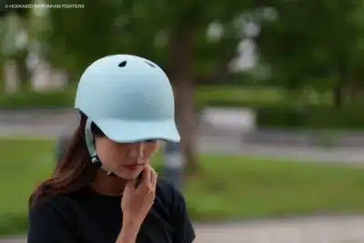 北海道日本ハムファイターズのヘルメットを着用した女性