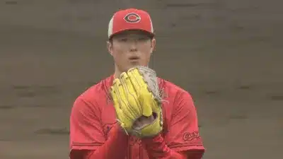 赤い野球帽とユニフォームを着用し、黄色いグローブをはめた野球選手