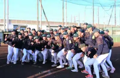 晴れた日の野球場で、ユニフォーム姿の野球部員たちが一体感のあるポーズで集合写真を撮っている。皆が笑顔で、チームの活気と絆を感じさせる一枚です。