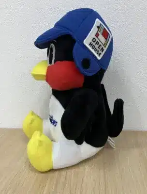 青い野球帽をかぶった黒と白のキャラクターのぬいぐるみ