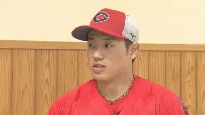 赤いキャップとユニフォームを着用した若い男性野球選手