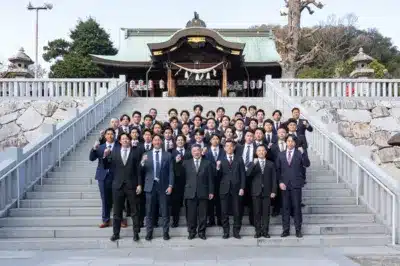 多くの男性がスーツ姿で集合写真を撮っている様子