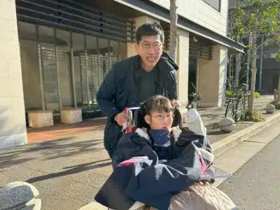 車椅子に乗った少女と男性
