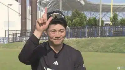 笑顔で指差しポーズをする男性アスリート