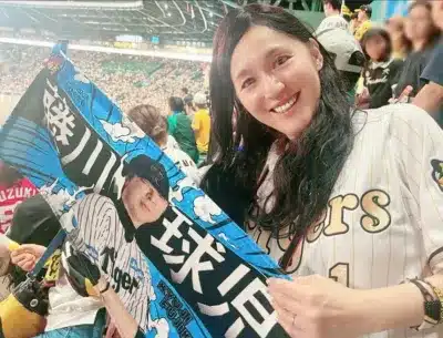 野球スタジアムで阪神タイガースを応援する女性