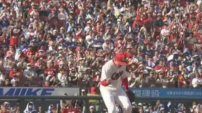 熱気あふれる野球スタジアムで、多くの観客が赤色のユニフォームを身に着けて応援する中、マウンド上の選手が感情を露わにしている瞬間