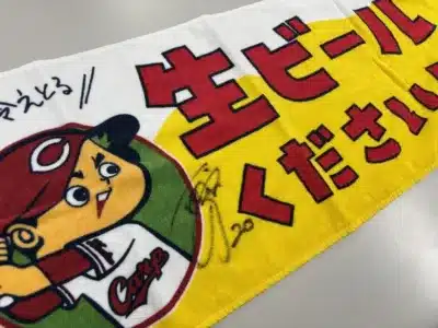 広島東洋カープのキャラクターが描かれた、白と黄色のタオル
