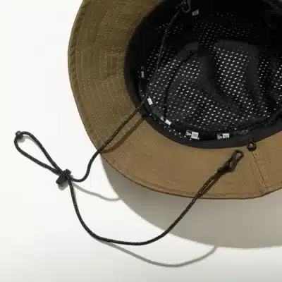 メッシュ素材と顎紐が付いたカーキ色のバケットハット