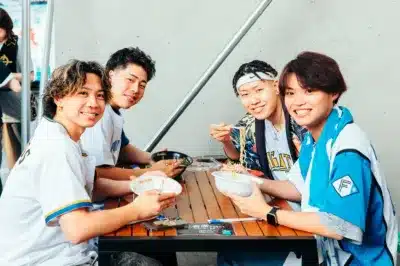 屋外のテーブルで食事を楽しむ男性グループ