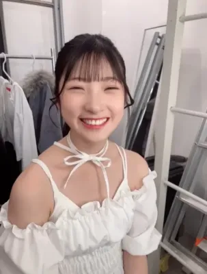 白いオフショルダーのトップスを着た若い女性の笑顔