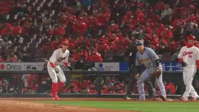野球の試合中の球場の様子。阪神タイガースと広島東洋カープの選手がフィールドにいる。赤いユニフォームを着た大勢の観客がスタンドを埋め尽くしており、熱気あふれる雰囲気です。