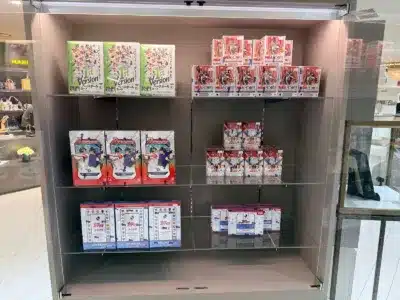 ショーケースの中に、野球、バスケットボール、Jリーグなど様々なスポーツのトレーディングカードボックスが整然と陳列されています