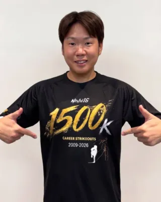 西勇輝選手がTシャツのデザインを指す