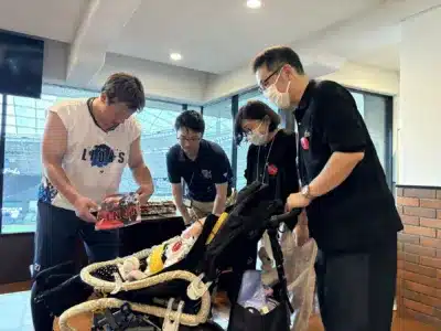 埼玉西武ライオンズの選手がスタジアム内でベビーカーに乗った赤ちゃんとその家族と交流する様子