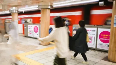 地下鉄ホームを通過する電車と広告