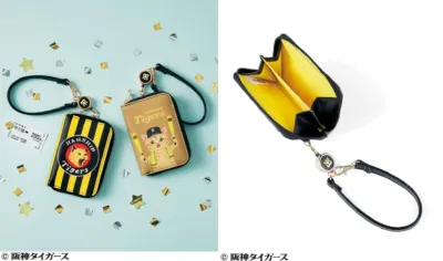 阪神タイガースのロゴ入りストライプ柄ポーチと、野球ユニフォームを着た猫のキャラクターがデザインされたポーチが並べられています。甲子園のチケットと紙吹雪が散りばめられ、ファン向けのアイテムであることを示唆しています。