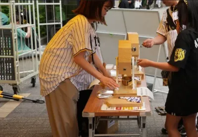 屋外イベント会場で抽選機を使って楽しむ人々