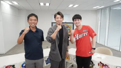 スタジオで3人の男性が笑顔でガッツポーズをしている様子