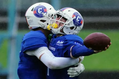 雨の中抱き合うアメフト選手たち