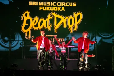 「SBI MUSIC CIRCUS FUKUOKA Beat Drop」のステージで、赤いジャケットを着たパフォーマーたちが躍動しています