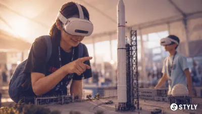 VRヘッドセットを装着した女性が、ロケット発射台の精巧なミニチュア模型を指差している