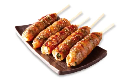 タレとゴマがかかった肉巻きおにぎりの串