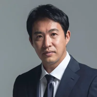 真剣な表情でカメラを見つめるアジア系の男性