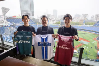 野球場を背景にユニフォームを掲げる3人の男性