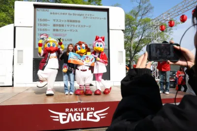 楽天イーグルスのイベントステージで、3体のマスコットと女性がファンと交流