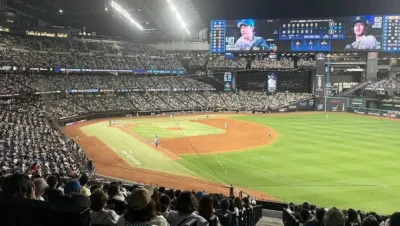 夜の野球場で試合を観戦する多くの観客