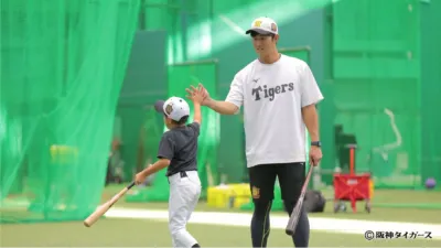 阪神タイガースと子供がハイタッチする様子